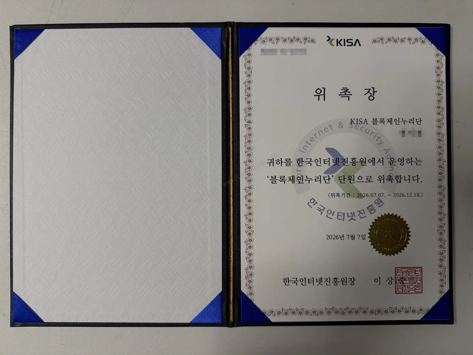 한국인터넷진흥원장 명의의 KISA 블록체인누리단 위촉장 - 위촉기간 2026년 7월 7일부터 12월 18일까지가 명시되어 있고 금박 직인이 찍혀 있습니다. 개인정보는 흐림 처리했습니다